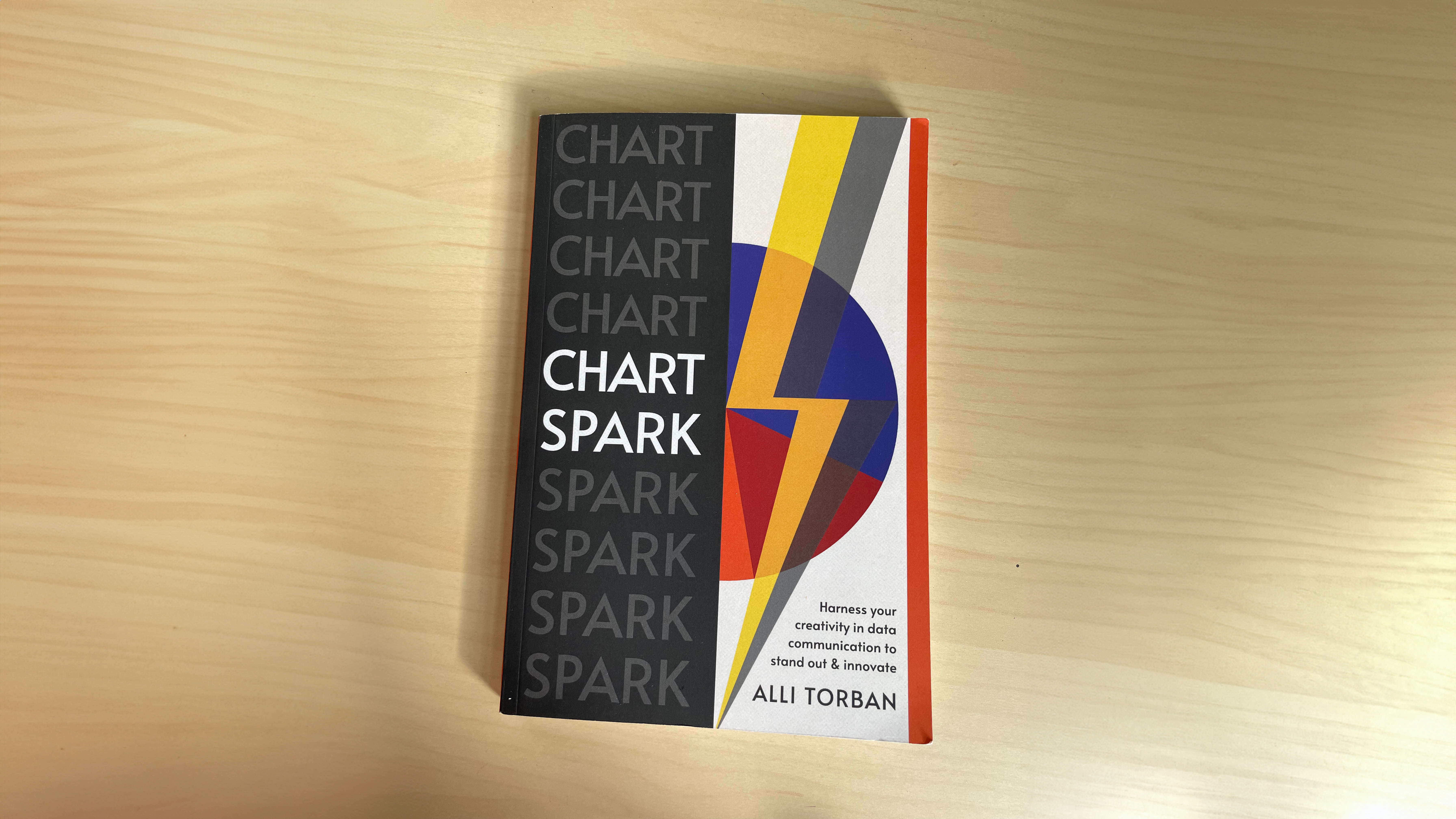 A book cover with the title "Chart Spark: Harness your creativity in data communication to stand out & innovate by Alli Torban" A lightning bolt going through a pie chart covers the right side of the cover while the title Chart Spark is repeated going down the left.